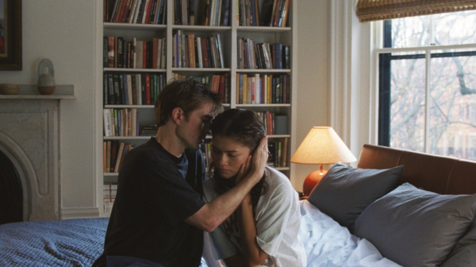 Zwischen Charlie (Robert Pattinson) und Emma (Zendaya) ist die Verbundenheit deutlich spürbar. Sie sitzen eng beieinander auf einem Bett in einem gemütlichen Zimmer mit Bücherregal.